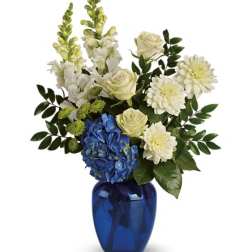 White and blue floral arrangement in a cobalt vase