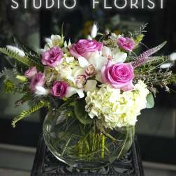 Pink roses and white hydrangeas in a round glass vase