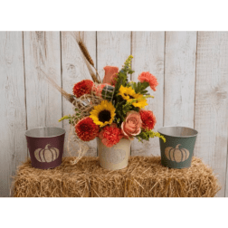Fall floral arrangement in a cream pot with sunflowers and orange blooms