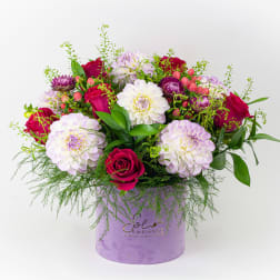 Mixed bouquet of pink and white flowers in a lavender hat box