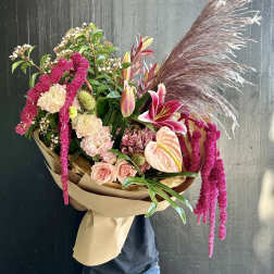Large bouquet with pink lilies, roses, and pampas grass wrapped in paper