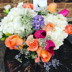 Bouquet of white hydrangeas with orange, pink, and purple flowers