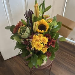 Mixed bouquet with a sunflower, yellow mums, lilies, and a succulent