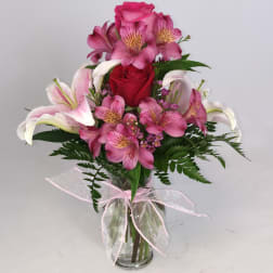 Pink and white mixed bouquet in a glass vase with a ribbon