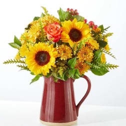 Sunflower and rose bouquet in a red ceramic pitcher
