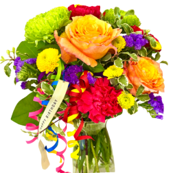 Colorful bouquet with roses, mums, and ribbon in a glass vase
