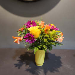 Yellow rose bouquet with purple daisies and orange alstroemeria in a yellow vase