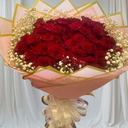Large bouquet of red roses with baby's breath in pink wrapping
