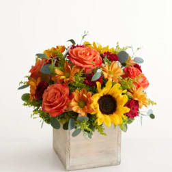 Mixed bouquet with roses, sunflowers, and daisies in a wooden box