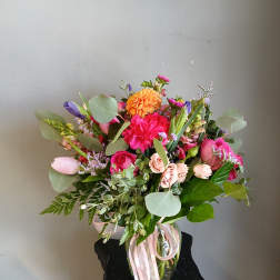 Mixed bouquet in a glass vase with pink, orange, and purple flowers