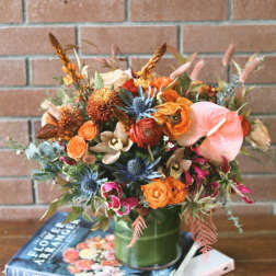 Orange and pink mixed bouquet in a green vase