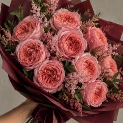 Bouquet of pink roses wrapped in burgundy paper