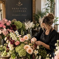 Florist arranging a pastel flower centerpiece with roses and hydrangeas