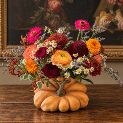 Mixed fall flowers arranged in a pumpkin-shaped container