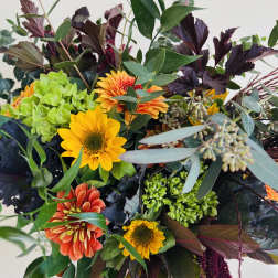 Mixed bouquet with sunflowers, orange blooms, and green hydrangea
