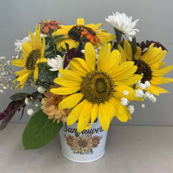 Sunflower bouquet in a white tin container with mixed accent flowers