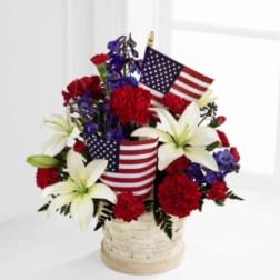 Basket arrangement of red carnations, white lilies, and American flags
