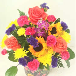 Colorful mixed bouquet with roses, sunflowers, and carnations in a patterned vase
