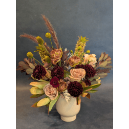 Mixed floral arrangement in a white vase with burgundy and blush blooms