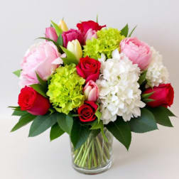 Bouquet of pink and red roses with hydrangeas in a glass vase