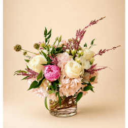 Bouquet of cream and pink roses in a clear glass vase