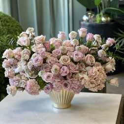 Pink and blush roses with hydrangeas in a cream vase