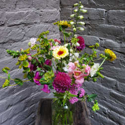 Mixed bouquet in a glass vase with pink, white, and yellow flowers