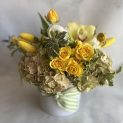 Yellow roses and lilies in a striped ceramic vase