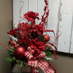 Red floral holiday arrangement with plaid ribbon, pinecones, and ornaments