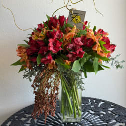 Bouquet of red and orange flowers in a clear glass vase