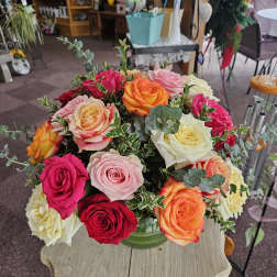 Mixed roses in a glass vase on a table