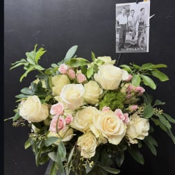 Cream and pink rose bouquet in a glass vase with greenery