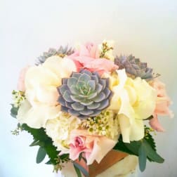 Bouquet of pastel roses and succulents in a vase