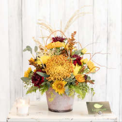 Autumn bouquet of yellow and burgundy flowers in a textured vase