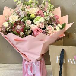 Pink bouquet with roses and mixed blooms wrapped in pink paper