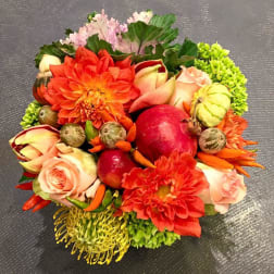 Round bouquet with orange dahlias, pale roses, and decorative gourds