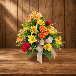 Mixed flower arrangement in a basket with a burlap bow