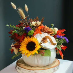 Fall floral arrangement in a white pumpkin container with a sunflower