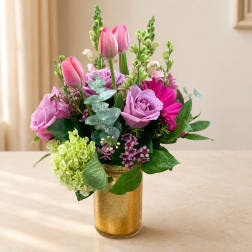 Pink and lavender bouquet in a gold vase with tulips and roses