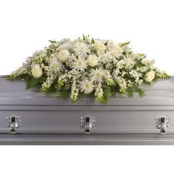 White floral casket spray with mixed blooms on a silver casket