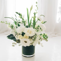 White floral arrangement in a dark glass vase