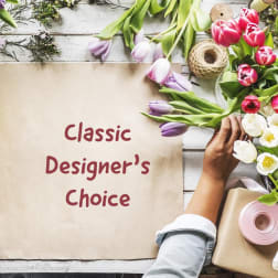 Tulips and wrapping supplies around a paper sign reading Classic Designer's Choice