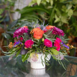 Bright mixed flower arrangement in a white vase