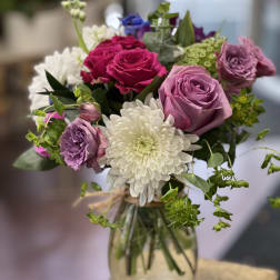 Bouquet of pink and purple roses with white chrysanthemum in a glass vase