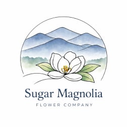Sugar Magnolia Flower Company logo with a white magnolia and blue mountains