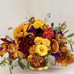 Autumn bouquet with yellow and red roses in a gold vase