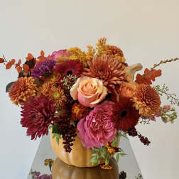 Autumn bouquet of mixed flowers in a pumpkin vase