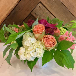 Bouquet of peach roses and white hydrangeas in a white vase