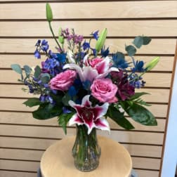 Pink and white lilies with pink roses in a glass vase
