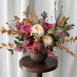 Pink and cream rose arrangement in a round vase